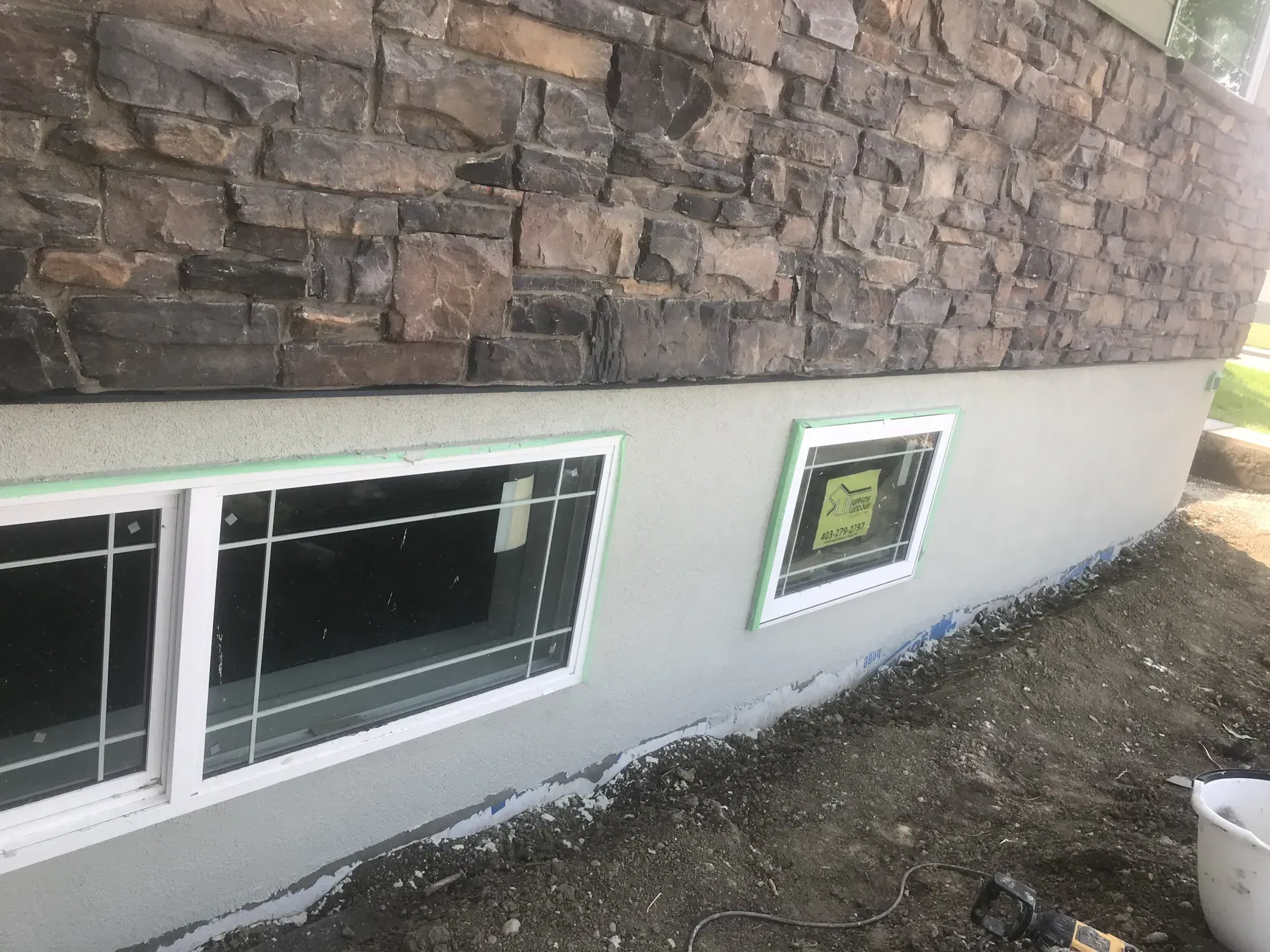 Stone veneer above new parging and basement windows