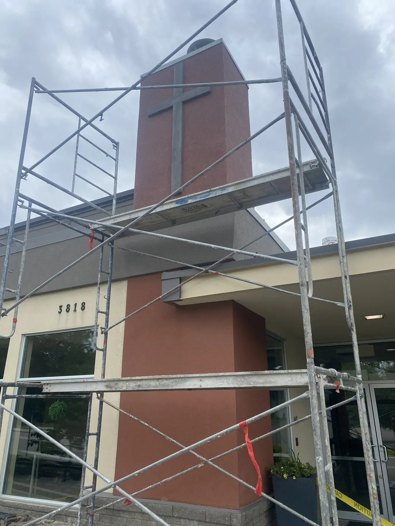 Church bell tower under scaffolding during an exterior stucco renovation