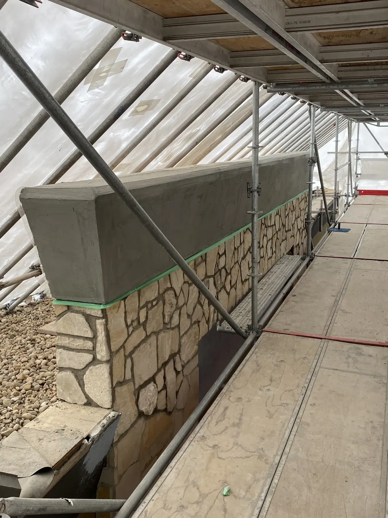 Stone wall and cap under heated hoarding