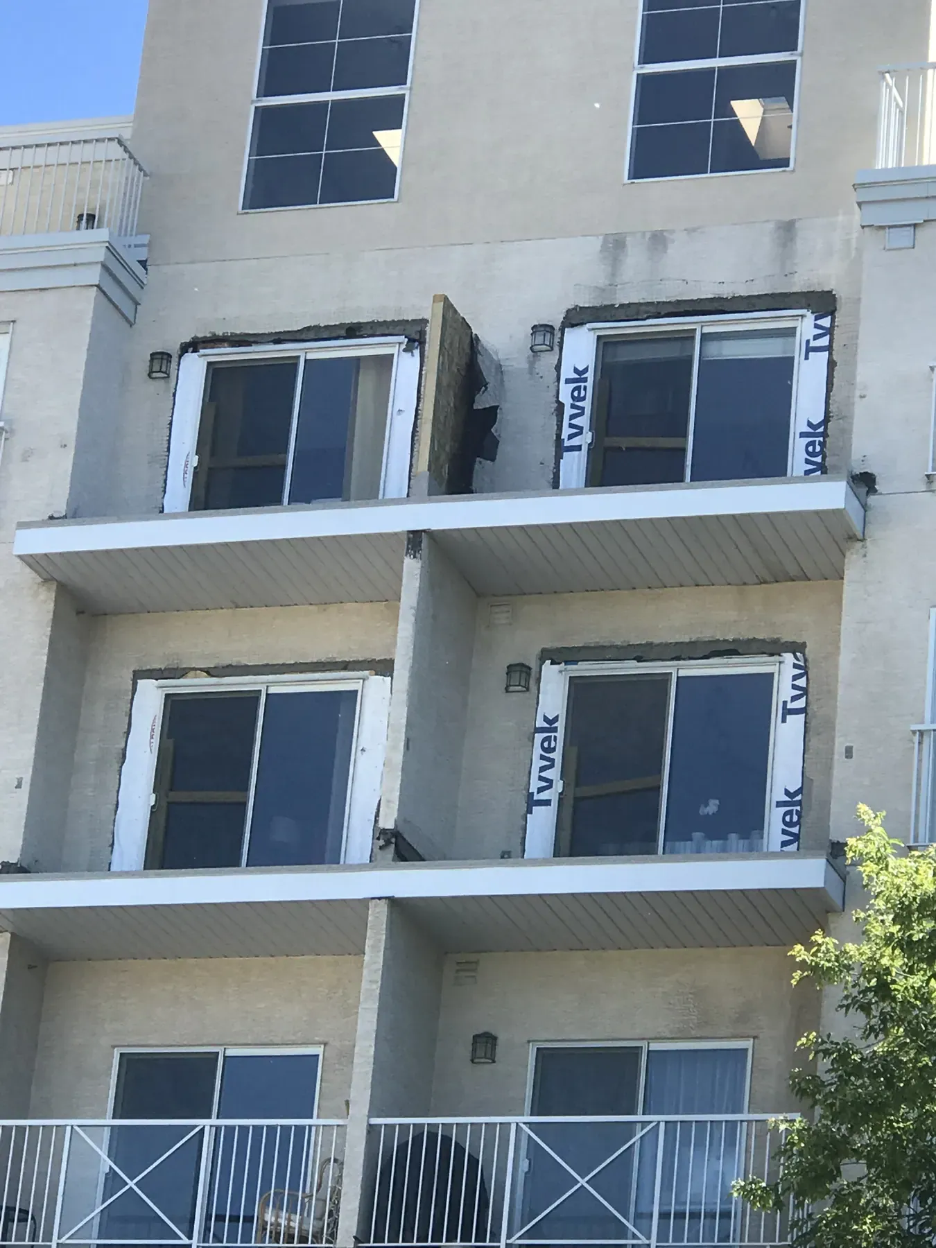 Condo balcony openings with new windows and house wrap during an envelope repair