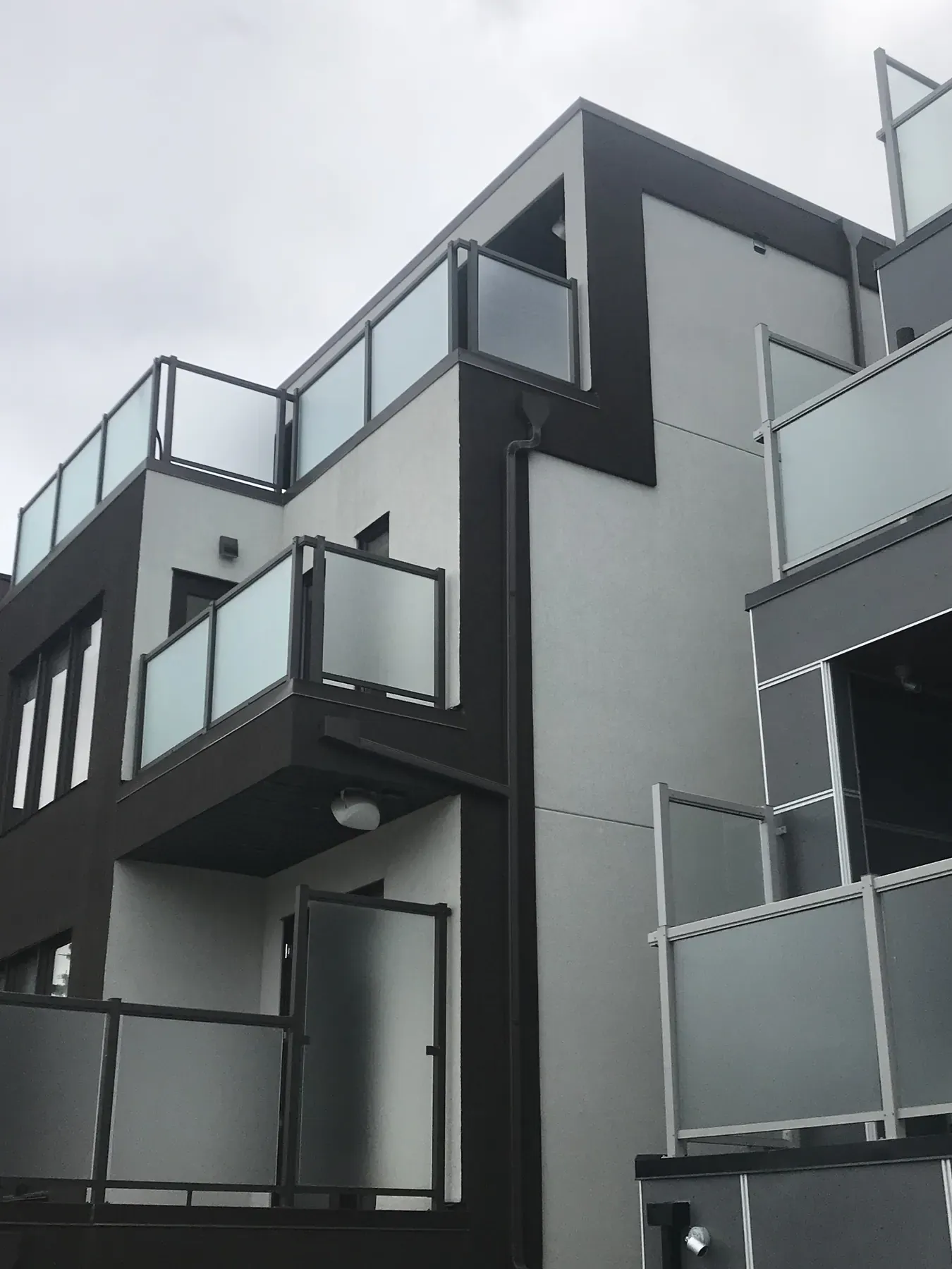 Infill rowhouse balconies with glass railings