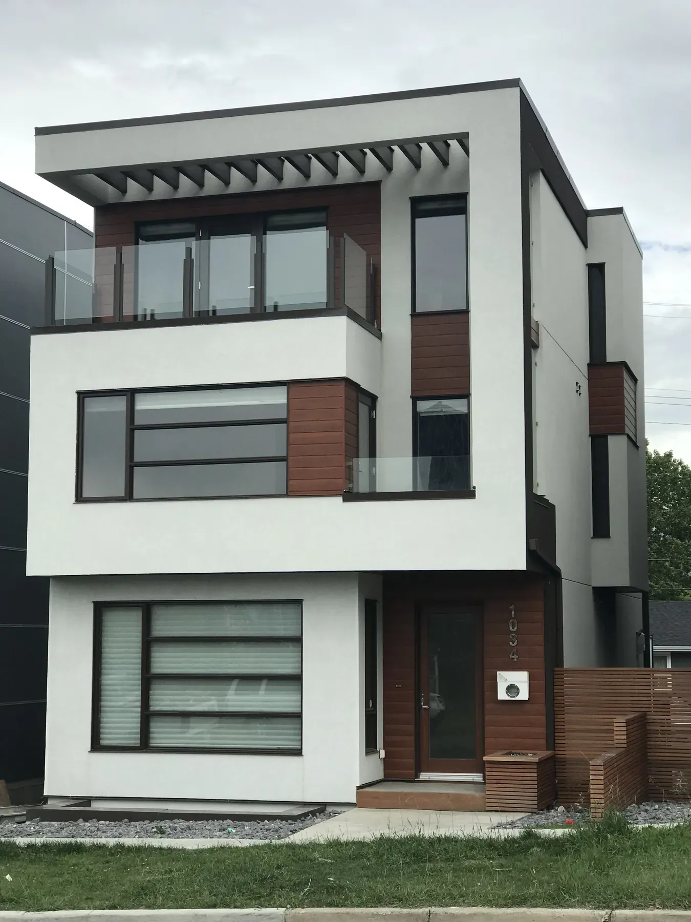 Three-storey infill with acrylic stucco and wood accents