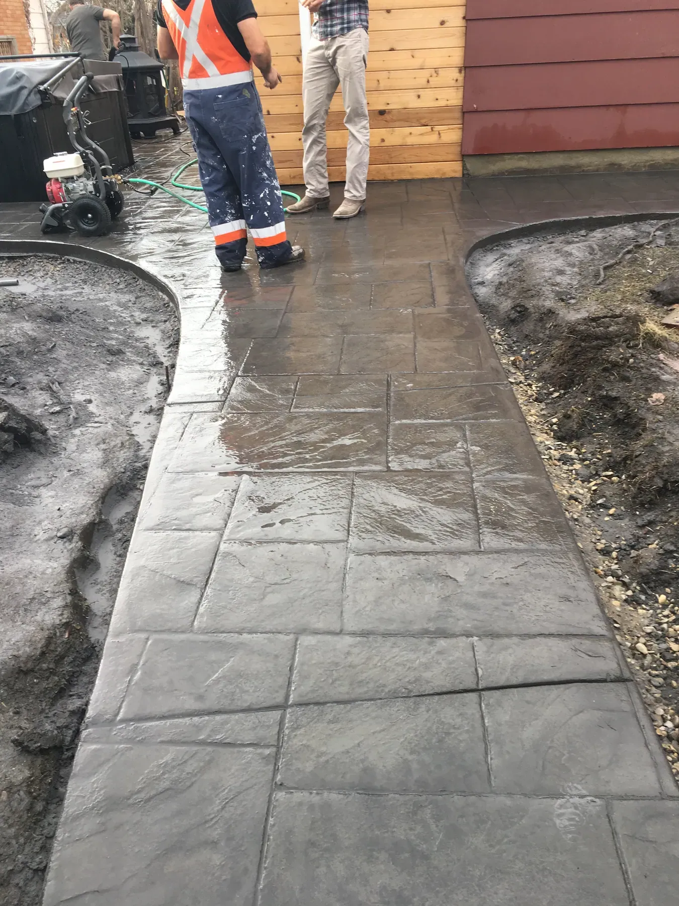 Stamped concrete walkway being sealed
